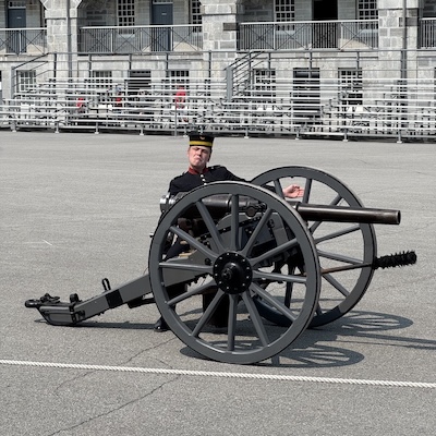 Guide en uniforme historique posant derrière un canon d’époque au Fort Henry.
