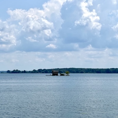 Minuscule île avec un chalet en bois au milieu de l’eau dans l’archipel des mille îles.