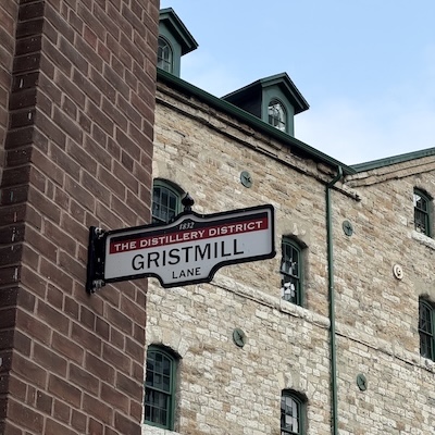 Plaque de rue « Gristmill Lane » fixée sur une mur de briques du Distillery District.