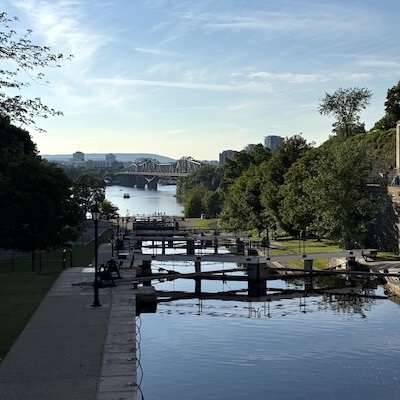 Alignement des écluses du Canal-Rideau à Ottawa menant vers la rivière, avec la ville de Gatineau en arrière plan.